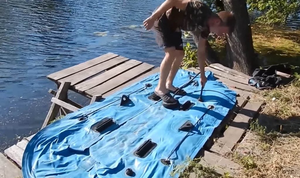Egy fickó épp felfúj egy gumicsónakot